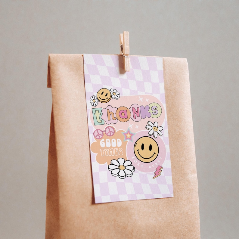 May include: A pink and purple thank you card with a checkered background. The card features a smiley face, peace sign, flowers, and the text "thanks good times".