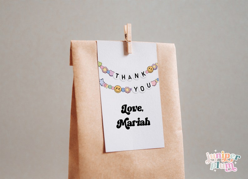 May include: A white card with a colorful beaded garland that says "Thank You" and "Love, Mariah" in black text. The card is attached to a brown paper bag.