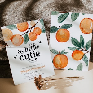 May include: A baby shower invitation with a watercolor illustration of oranges and leaves. The text reads "a little cutie is on the way!" and includes the name "Megan Whitmore" and details for the event.