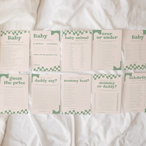 May include: A set of ten baby shower game cards in light pink with sage green text and checkerboard accents. Titles include Baby True or False, Predictions & Advice, Baby Animal Matching, Over or Under, Word Scramble, Guess the Price, What Did Daddy Say?, Who Knows Mommy Best?, Guess Who Mommy or Daddy?, and Celebrity Baby Names.