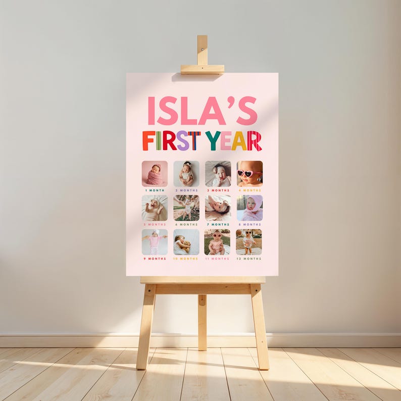 May include: A light pink poster titled ISLA'S FIRST YEAR in bold letters, featuring twelve square photographs arranged in a grid. Each photo is labeled with a month from 1 month to 12 months, documenting a baby's growth milestones.
