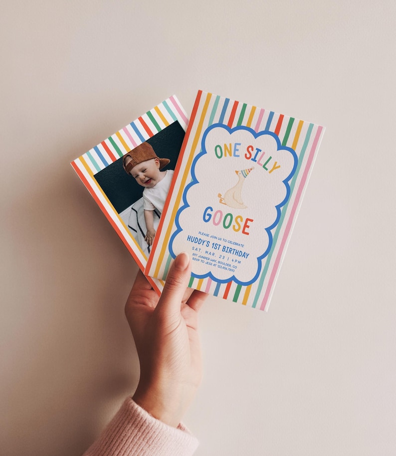 May include: Two colorful birthday invitations are held in a hand. One invitation features a photo of a baby wearing a cap. The other invitation has the text "ONE SILLY GOOSE" in a cloud-shaped design, with the event details below.