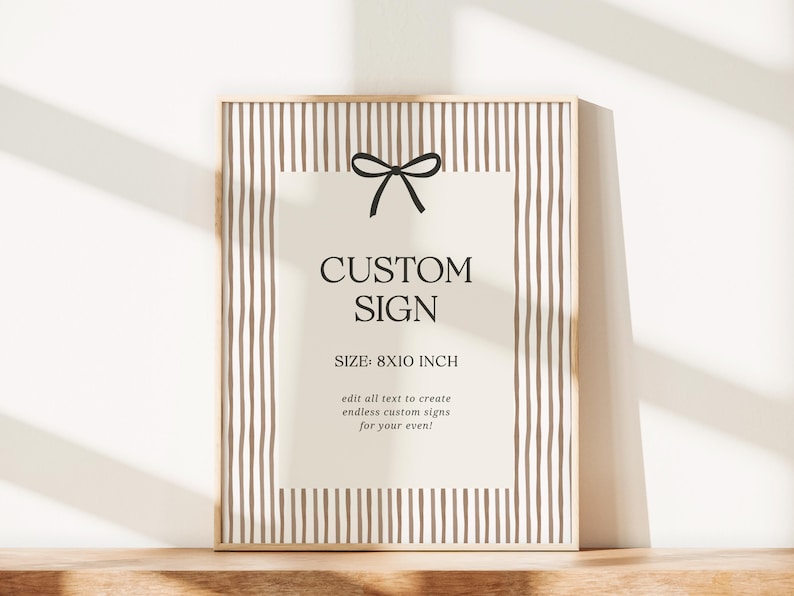 Pode incluir: Uma placa personalizada emoldurada com fundo bege e listras verticais marrons. A placa apresenta o texto "CUSTOM SIGN" e "TAMANHO: 20x25 cm" com um la&ccedil;o preto. A moldura &eacute; de cor de madeira clara.