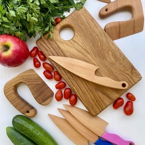 Puede incluir: Juego de cocina de madera para ni&ntilde;os con tabla de cortar, cuchillos y verduras. El juego incluye una manzana roja, pepinos verdes y tomates rojos. Los cuchillos tienen mangos de colores.