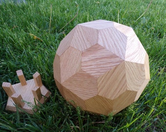 May include: A wooden geometric sphere with a faceted design, alongside a small wooden stand. The sphere is made of light-colored wood and has a complex, multi-sided shape. The stand is square with four upright supports.