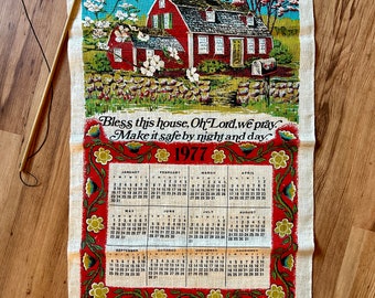 May include: A vintage tea towel with a red farmhouse and blooming trees. The towel features a calendar for the year 1977 and the text "Bless this house, Oh Lord, we pray. Make it safe by night and day."