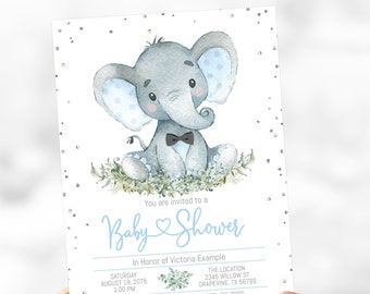 May include: A baby shower invitation with a cute cartoon elephant wearing a bow tie. The invitation is decorated with silver glitter and blue and green floral accents. The text on the invitation reads "You are invited to a Baby Shower In Honor of Victoria Example Saturday August 18, 2075 1:00 PM The Location 2345 Willow St Grapevine, TX 56789 RSVP to Lauren - Call or Text 123-456-7890 Victoria is registered at Store One & Store Two"