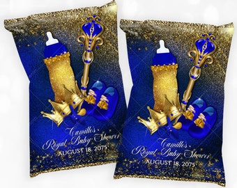 Pode incluir: Embrulhos de sacos de batatas fritas azuis e dourados com um tema de chá de bebê real. O design apresenta uma coroa, um cetro, uma mamadeira e sapatos de bebê azuis. O texto diz "Camille's Royal Baby Shower August 18, 2075".