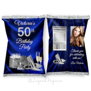 May include: Blue and silver chip bag with a silver glitter border. The bag features a design of a pair of silver high heels, a champagne flute, and a gift box with a bow. The text "Victoria's 50th Birthday Party" is printed on the bag.