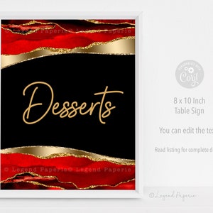 May include: A framed 8 x 10 inch table sign with a black background and the word "Desserts" in gold script. The top and bottom of the sign feature red watercolor and gold glitter accents. The sign is in a white frame.