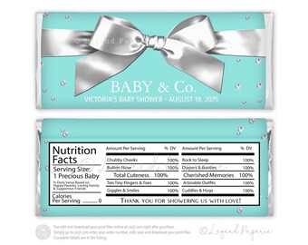 May include: A turquoise and silver baby shower chocolate bar wrapper with a silver bow and diamond-like accents. The wrapper says "BABY & Co." and "VICTORIA'S BABY SHOWER - AUGUST 18, 2075". The back of the wrapper has a nutrition facts label with a humorous list of baby-related items.