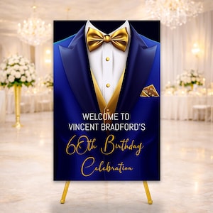 May include: A sign with a blue tuxedo jacket design, gold bow tie and vest. The sign reads "Welcome to Vincent Bradford's 60th Birthday Celebration" in gold script. The sign is displayed on a gold easel, suitable for a party.