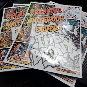 May include: A stack of seven creative notebook covers featuring a graffiti-style design with the words "The Bronx" in white letters. The covers are printed on white paper and have a glossy finish. The text "7 Creative Covers Included" is printed on the bottom of the covers.
