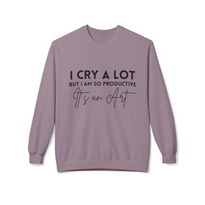 May include: A mauve long-sleeved sweatshirt with the text "I cry a lot but I am so productive It's an Art" printed in black.