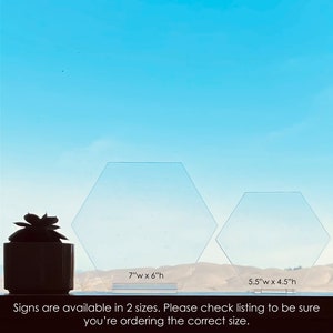 May include: Two clear acrylic hexagonal signs, one measuring 7 inches wide by 6 inches high and the other measuring 5.5 inches wide by 4.5 inches high. The signs are displayed against a blue sky background. The text "Signs are available in 2 sizes. Please check listing to be sure you're ordering the correct size." is displayed below the signs.