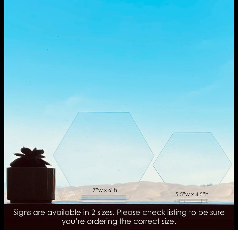 May include: Two clear acrylic hexagonal signs, one measuring 7 inches wide by 6 inches high and the other measuring 5.5 inches wide by 4.5 inches high. The signs are displayed against a blue sky background. The text "Signs are available in 2 sizes. Please check listing to be sure you're ordering the correct size." is displayed below the signs.