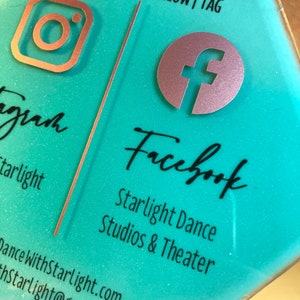 May include: A turquoise hexagonal sign with the text "LIKE | SHARE | FOLLOW | TAG" at the top. The left side of the sign features an Instagram logo and the text "gram starlight" and the right side features a Facebook logo and the text "Facebook Starlight Dance Studios & Theater Dance WithStarlight.com hStarlight@gmail.com".