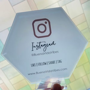 May include: White hexagonal sign with a pink Instagram logo and the text "Instagram @BuenaVidaVibes LIKE | FOLLOW | SHARE | TAG www.BuenaVidaVibes.com"