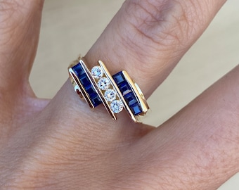 Unico anello a fascia con diamanti rotondi con zaffiro blu taglio principessa in oro giallo 14k