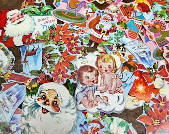 May include: A collection of vintage Christmas die-cut paper decorations. The assortment includes Santa Claus figures, angels, poinsettias, and other festive images in various colors. Some decorations have text that reads "DON'T OPEN 'TIL".