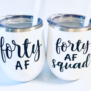May include: Two white stainless steel wine tumblers with black vinyl lettering. The tumbler on the left says "forty AF" and the tumbler on the right says "forty AF squad".