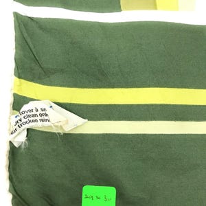 Może przedstawiać: Zielono-ż&oacute;łta tkanina w paski z białym obramowaniem. Tkanina ma metkę z napisem "30 x 29" i "7401".