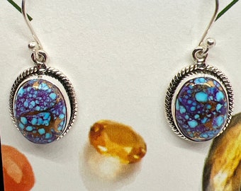 May include: A pair of silver dangle earrings with oval-shaped turquoise stones. The stones have a blue, purple, and brown marbled pattern.