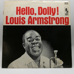 May include: Vintage vinyl record album cover for "Hello, Dolly!" by Louis Armstrong. The cover features the album title and artist's name in red text against a white and black background. A black and white image of Louis Armstrong is featured on the cover.