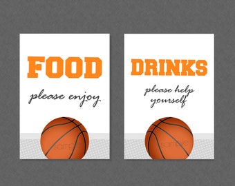 May include: Two white signs with black text and an orange basketball graphic. The first sign says "FOOD please enjoy" and the second sign says "DRINKS please help yourself".