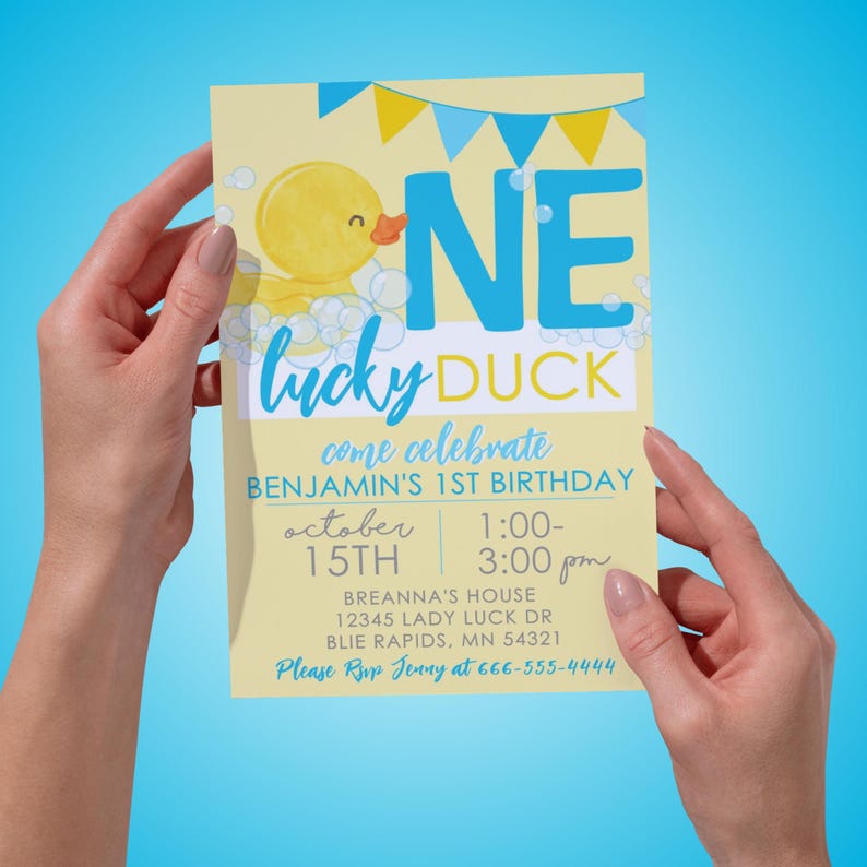 Puede incluir: Una invitaci&oacute;n de cumplea&ntilde;os amarilla y azul con un pato de goma de dibujos animados y el texto "One Lucky Duck" y "Come Celebrate Benjamin's 1st Birthday". La invitaci&oacute;n incluye la fecha "October 15th" y la hora "1:00-3:00 pm".