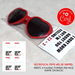 Peut inclure: T&eacute;l&eacute;chargement num&eacute;rique imprimable de quatre lunettes de soleil en forme de c&oelig;ur avec le texte "Je ne sais pas pour toi mais je me sens 22+2" sur la carte. Les lunettes de soleil sont rouges avec des verres noirs. La carte est blanche avec du texte noir.