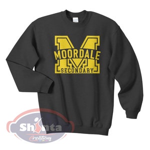 K&ouml;nnte beinhalten: Ein dunkelgrauer Pullover mit einem gelben Aufdruck des Buchstabens "M" und dem Text "MOORDALE SECONDARY".