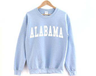 May include: Light blue sweatshirt with the word "ALABAMA" printed in white on the front.