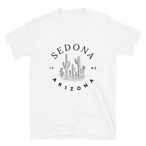 May include: White t-shirt with a black graphic of a circle with the text "SEDONA 1902 ARIZONA" and a drawing of cacti inside the circle.