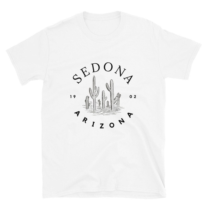 May include: White t-shirt with a black graphic of a circle with the text "SEDONA 1902 ARIZONA" and a drawing of cacti inside the circle.
