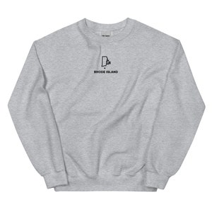May include: A gray sweatshirt with a black outline of the state of Rhode Island and the text "RHODE ISLAND" underneath.