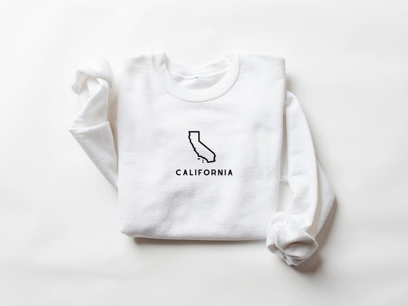 May include: White long-sleeved sweatshirt with a black outline of the state of California and the word "CALIFORNIA" printed below.