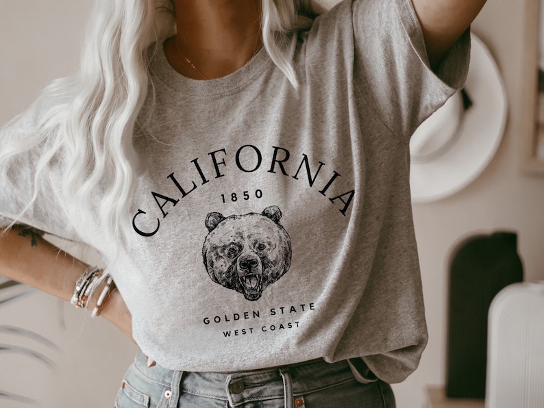 May include: Gray t-shirt with a black graphic of a bear and the text "CALIFORNIA 1850 GOLDEN STATE WEST COAST".