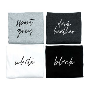 May include: Four folded fabric squares in sport grey, dark heather, white, and black. Each square has a handwritten style text label indicating the color. The image is on a white background.