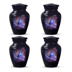 May include: Four small, dark purple, ceramic urns with lids. Each urn features a white butterfly with blue wings on a purple floral background.