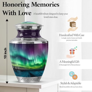 May include: A 10-inch tall urn with a vibrant aurora borealis design in shades of purple, green, and blue. The urn has a silver-colored lid and base with decorative detailing. The text on the image says "Honoring Memories With Love."