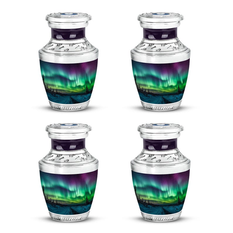 May include: Four silver-toned urns with a vibrant design of the aurora borealis. The urns feature a dark purple band and a detailed silver rim. The image on the urns depicts a colorful display of green and purple lights over a landscape.