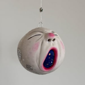 Handgemaakt ambachtelijk ornament met geeuwende volle maan: decoratie in vintage stijl