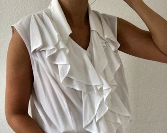 Belle blouse vintage sans manches en blanc avec des froufrs