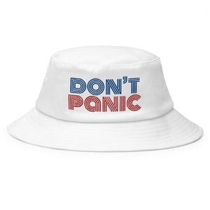 Peut inclure: Chapeau bob blanc avec le texte "DON'T PANIC" en lettres rayées rouges et bleues.