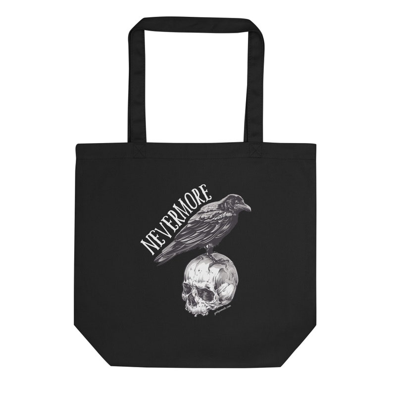 Może przedstawiać: Czarna torba typu tote z białym nadrukiem przedstawiającym kruka siedzącego na czaszce. Tekst "NEVERMORE" jest napisany stylizowanym fontem.