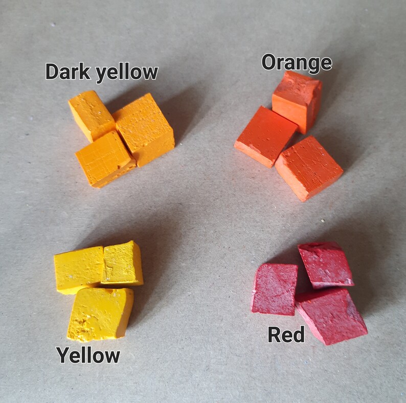 以下が含まれることがあります： 正方形に配置された4つの小さな色のチョークブロック。色は濃い黄色、オレンジ、黄色、赤です。