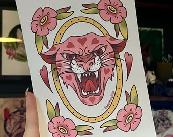 May include: A pink panther head with hearts on its fur, surrounded by pink flowers and a gold oval frame. The image has the text "@kellyrobuccatatto" at the bottom.