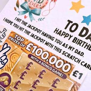 Puede incluir: Tarjeta de cumplea&ntilde;os con un rasca y gana. La tarjeta dice "Best Dad Ever" y "To Dad, Happy Birthday". El rasca y gana muestra un premio de &pound;100,000 y un juego de bonificaci&oacute;n.