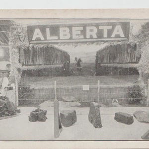 May include: A black and white photograph of a display of rocks in front of a fence. The display is labelled "ALBERTA".